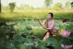 Asiatische Schönheit, die auf dem Lotosgebiet geht lizenzfreies stockfoto Asiatische Schönheit, die auf dem Lotosgebiet geht lizenzfreies stockfoto