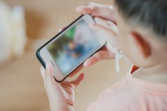 Asiatischer Kinderjungenholding- und -touch Screen von Smartphone lizenzfreie stockfotografie Asiatischer Kinderjungenholding- und -touch Screen von Smartphone lizenzfreie stockfotografie