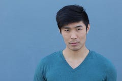 Asiatischer Mann mit ernstem Ausdruck über blauem Hintergrund mit Kopienraum stockbild Asiatischer Mann mit ernstem Ausdruck über blauem Hintergrund mit Kopienraum stockbild