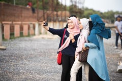 Asiatisk hijabflicka som tar fotoet royaltyfri foto Asiatisk hijabflicka som tar fotoet royaltyfri foto