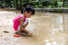 Asiatisk kinesisk liten flicka som spelar leksakfartyget på liten vik royaltyfria foton Asiatisk kinesisk liten flicka som spelar leksakfartyget på liten vik royaltyfria foton