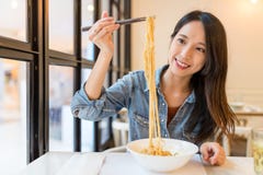 Asiatisk kvinna som äter nudlar i kinesisk restaurang arkivbild Asiatisk kvinna som äter nudlar i kinesisk restaurang arkivbild