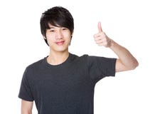 Asiatisk visningtumme för ung man upp Arkivfoto Asiatisk visningtumme för ung man upp Arkivfoto