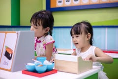 Asiatiska kinesiska små systrar som roll-spelar på sushilagret arkivbilder Asiatiska kinesiska små systrar som roll-spelar på sushilagret arkivbilder