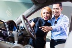 Asiatiska par som väljer den lyxiga bilen i återförsäljare Royaltyfria Foton Asiatiska par som väljer den lyxiga bilen i återförsäljare Royaltyfria Foton