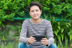 Asiatiskt mansammanträde och användasmartphone arkivbild Asiatiskt mansammanträde och användasmartphone arkivbild