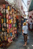 Asilah, Μαρόκο - 14 Αυγούστου 2013: Μη αναγνωρισμένη νέα γυναίκα που εξετάζει πολλά παπούτσια δέρματος για την πώληση στην οδό στοκ φωτογραφία με δικαίωμα ελεύθερης χρήσης Asilah, Μαρόκο - 14 Αυγούστου 2013: Μη αναγνωρισμένη νέα γυναίκα που εξετάζει πολλά παπούτσια δέρματος για την πώληση στην οδό στοκ φωτογραφία με δικαίωμα ελεύθερης χρήσης