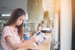 Asiático novo que lê o livro que senta-se na barra da mesa fotos de stock Asiático novo que lê o livro que senta-se na barra da mesa fotos de stock