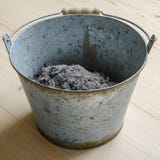 Aska i en metallhink arkivbild Aska i en metallhink arkivbild