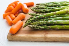Asparagus and Carrots Close Up on a Wooden Chopping Board stock photos Asparagus and Carrots Close Up on a Wooden Chopping Board stock photos