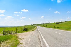 Asphalt long road crossing the green valley in a sunny summer day with bright blue sky stock images Asphalt long road crossing the green valley in a sunny summer day with bright blue sky stock images