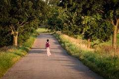 Asphalt road leading among trees. In the middle of the road lone stock image Asphalt road leading among trees. In the middle of the road lone stock image