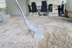 Aspirapolvere che rimuove sporcizia su tappeto bianco immagine stock Aspirapolvere che rimuove sporcizia su tappeto bianco immagine stock