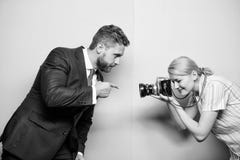 Assegurando-se de que seu gesto seja afiado e focalizado Homem de neg?cios que levanta para o fot?grafo f?mea Sess?o fotogr?fica imagem de stock Assegurando-se de que seu gesto seja afiado e focalizado Homem de neg?cios que levanta para o fot?grafo f?mea Sess?o fotogr?fica imagem de stock