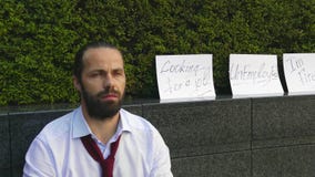Assento ateado fogo do homem de neg?cio frustrado e virado na rua perto do pr?dio de escrit?rios com a caixa de seus pertences Pe video estoque Assento ateado fogo do homem de neg?cio frustrado e virado na rua perto do pr?dio de escrit?rios com a caixa de seus pertences Pe video estoque
