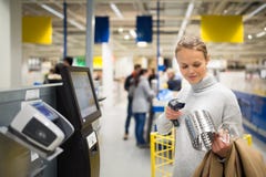 Assez, jeune femme employant le contrôle de service d'individu dans un magasin image stock Assez, jeune femme employant le contrôle de service d'individu dans un magasin image stock