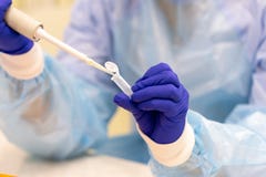 Assistente di laboratorio con una pipetta in sue mani per analisi del sangue fotografia stock libera da diritti Assistente di laboratorio con una pipetta in sue mani per analisi del sangue fotografia stock libera da diritti