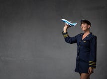 Assistente di volo che plaing con un aereo del giocattolo Immagine Stock Assistente di volo che plaing con un aereo del giocattolo Immagine Stock