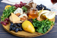Assortiment d'apéritif : raisins, fromage, fromage bleu, figues, melon, arugula, pain de grain, miel photo libre de droits Assortiment d'apéritif : raisins, fromage, fromage bleu, figues, melon, arugula, pain de grain, miel photo libre de droits