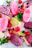 Assortment of Berry Popsicles with Mint Leaves on Ice Cubes stock photos Assortment of Berry Popsicles with Mint Leaves on Ice Cubes stock photos