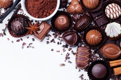 Assortment of chocolate candies, cocoa products and spices on white background. Top view. Copy space. Royalty Free Stock Image Assortment of chocolate candies, cocoa products and spices on white background. Top view. Copy space. Royalty Free Stock Image