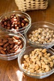 Assortment of mixed nuts and wicker basket on wood table background stock image Assortment of mixed nuts and wicker basket on wood table background stock image