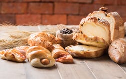 Assortment Of Baked Bread And Wheat On Wood Table Royalty Free Stock Photography