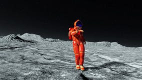 Astronauta en traje anaranjado del exo que explora y que baila alrededor Astronauta en traje anaranjado del exo que explora y que baila alrededor