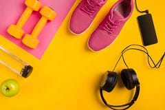 Athlete`s set with female clothing, dumbbells and bottle of water on yellow background Stock Photos Athlete`s set with female clothing, dumbbells and bottle of water on yellow background Stock Photos