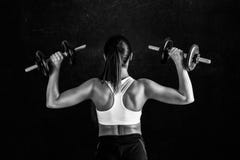 Athletic young woman doing a fitness workout against black background. Attractive fitness girl pumping up muscles with dumbbells. stock photos Athletic young woman doing a fitness workout against black background. Attractive fitness girl pumping up muscles with dumbbells. stock photos
