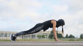 Athlète de jeune femme de forme physique faisant l'exercice de planche sur le stade photographie stock libre de droits Athlète de jeune femme de forme physique faisant l'exercice de planche sur le stade photographie stock libre de droits