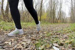 Atleta della ragazza in scarpe da tennis e ghette che corre lungo il percorso Fotografia Stock Atleta della ragazza in scarpe da tennis e ghette che corre lungo il percorso Fotografia Stock