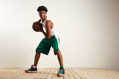 Atleta preto de sorriso dos jovens que joga o basquetebol imagem de stock royalty free Atleta preto de sorriso dos jovens que joga o basquetebol imagem de stock royalty free