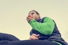 Atletische vrouw die een gezonde fruitsnack hebben tijdens openluchtoefening royalty-vrije stock foto Atletische vrouw die een gezonde fruitsnack hebben tijdens openluchtoefening royalty-vrije stock foto