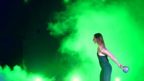 Atlética, bonito, a jovem mulher que faz a vária força exercita com pesos Na noite, à vista de colorido filme Atlética, bonito, a jovem mulher que faz a vária força exercita com pesos Na noite, à vista de colorido filme