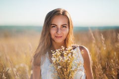 Atrakcyjna młoda kobieta stoi ono uśmiecha się w łące na zmierzchu obraz stock Atrakcyjna młoda kobieta stoi ono uśmiecha się w łące na zmierzchu obraz stock