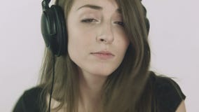 Atrakcyjna młoda kobieta słucha muzyka na hełmofonach zbiory wideo Atrakcyjna młoda kobieta słucha muzyka na hełmofonach zbiory wideo