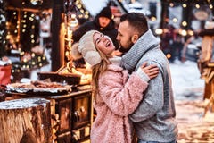 Atrakcyjna para w miłości, cieszy się wydający czas wpólnie podczas gdy obejmujący przy zima jarmarkiem przy Bożenarodzeniowym cz obrazy stock Atrakcyjna para w miłości, cieszy się wydający czas wpólnie podczas gdy obejmujący przy zima jarmarkiem przy Bożenarodzeniowym cz obrazy stock