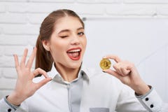 Atrakcyjnego potomstwa wzorcowego mienia złoty bitcoin i seansu ok podpisujemy zdjęcia stock Atrakcyjnego potomstwa wzorcowego mienia złoty bitcoin i seansu ok podpisujemy zdjęcia stock