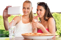 Atrakcyjni żeńscy przyjaciele bierze selfie z smartphone fotografia stock Atrakcyjni żeńscy przyjaciele bierze selfie z smartphone fotografia stock