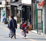Atrás do homem japonês em Yukata para os homens e a mulher no vestido do quimono que andam na passagem foto de stock royalty free Atrás do homem japonês em Yukata para os homens e a mulher no vestido do quimono que andam na passagem foto de stock royalty free