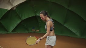 Att le, den lyckliga unga kvinnan i sportswear och långt hår gör en bred serveboll i tennis Starkt skott långsam rörelse lager videofilmer Att le, den lyckliga unga kvinnan i sportswear och långt hår gör en bred serveboll i tennis Starkt skott långsam rörelse lager videofilmer
