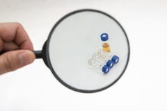 Att räcka förstorar exponeringsglas på prövkopialilla medicinflaskan royaltyfria bilder Att räcka förstorar exponeringsglas på prövkopialilla medicinflaskan royaltyfria bilder