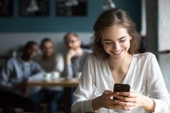 Attention se sentante de sourire de jeune fille des types de flirt en café images libres de droits Attention se sentante de sourire de jeune fille des types de flirt en café images libres de droits
