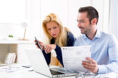 Attractive couple doing administrative paperwork stock image Attractive couple doing administrative paperwork stock image