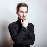 Attractive elegant man in black golf posing on light gray background. stock image Attractive elegant man in black golf posing on light gray background. stock image