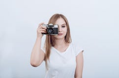 Attractive girl holding a vintage camera in her hands. Take a picture