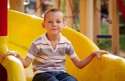 Attractive little boy on a slide in a playground royalty free stock image Attractive little boy on a slide in a playground royalty free stock image