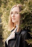 Woman near green hedge. Attractive young woman near green hedge looking at camera Stock Image Woman near green hedge. Attractive young woman near green hedge looking at camera Stock Image