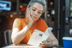 Attraktiv blond flickaläsebok på kafét arkivfoto Attraktiv blond flickaläsebok på kafét arkivfoto